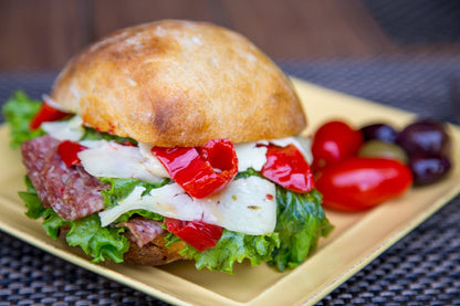 a sandwich with cheese, meat, lettuce, and Mama Lil's peppers